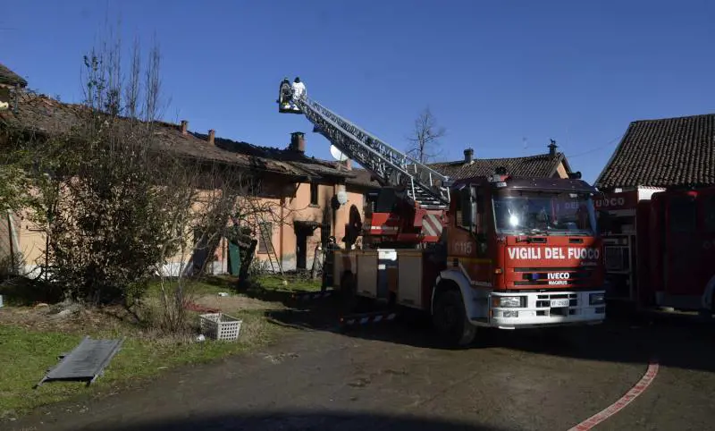 I vigili del fuoco lavorano, dopo avere domato l'incendio, nella cascina