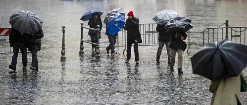 Passanti provano a ripararsi dalla pioggia a Roma / Archivio