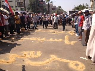 Manifestazione pro Morsi. "Vattene Al Sisi" scritto con la sabbia