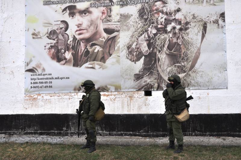 Soldati russi soto un murales di arruolamento dell'esercito ucraino