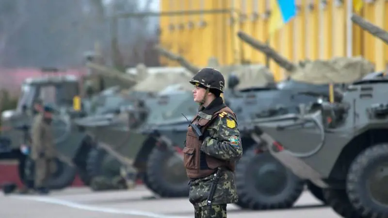 Un soldato ucraino di guardia a mezzi dell'esercito a Lviv, nell'Ucraina occidentale