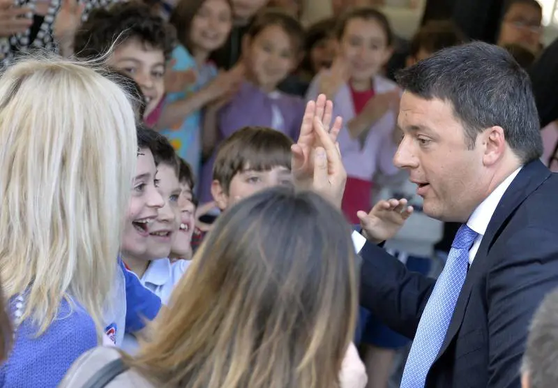 Il premier Matteo Renzi saluta glni alunni della scuola Massaua a Milano