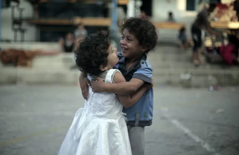 Due bambine palestinesi fotografe in una scuola delle Nazioni Unite