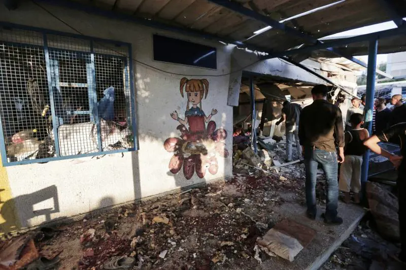 Un gruppo di palestinesi fuori dalle aule della scuola Abu Hussein, gestita dall'Onu a Jabaliya