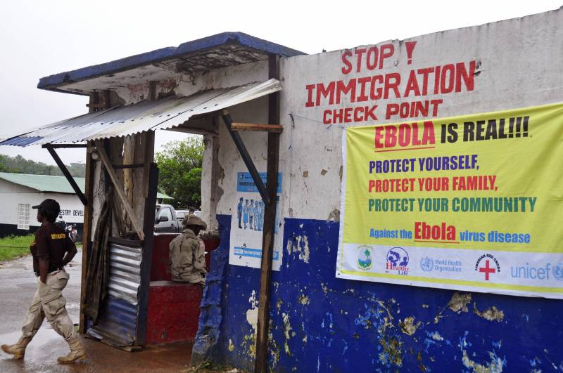 Manifesti sui muri di un posto di blocco in Liberia invitano a cautelarsi contro l'ebola