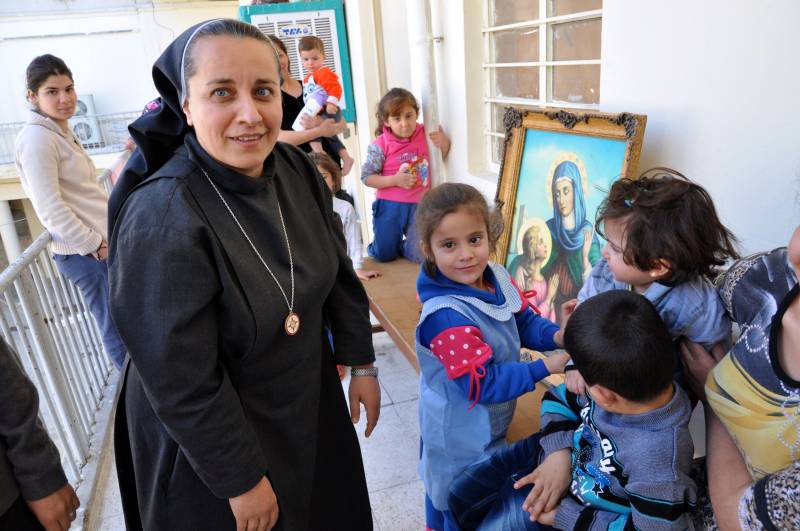 Bambini delle famiglie cristiane sfollate a Baghdad con suor Mariam della chiesa della Vergine Maria