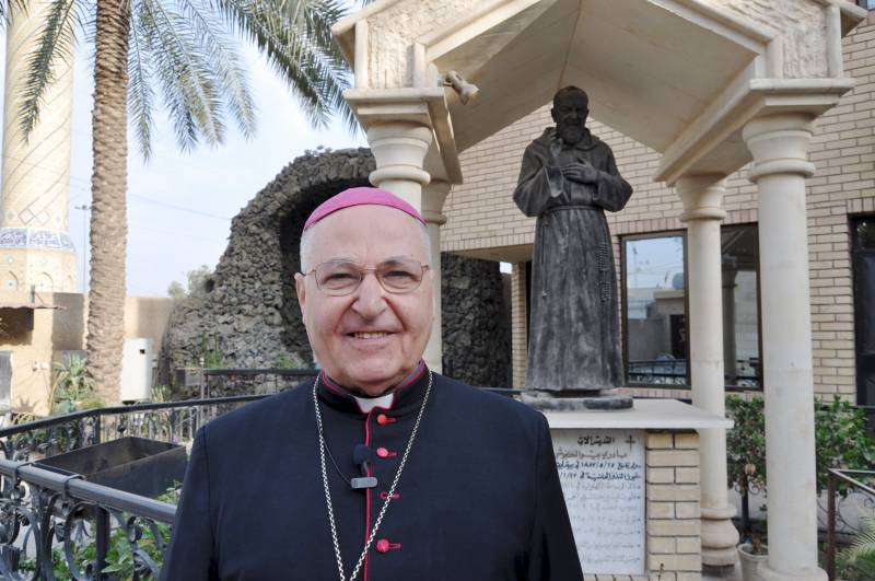 Monsignor Shlemon Warduni nella parrocchia del Sacro cuore di Baghdad davanti alla statua di padre Pio