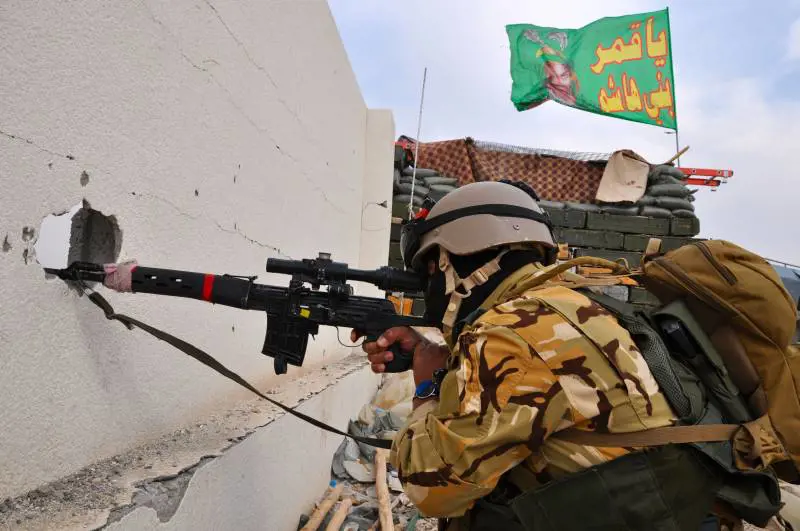 Cecchino dei corpi speciali irahceni a Tikrit. Sullo sfondo al bandiera con l'imam Hussein venerato dagli sciiti