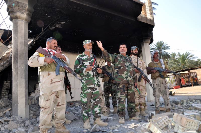 Il colonnello Abbas Al Assady con i suoi uomini, volontari di Karbala, la città santa sciita, davanti alla dimora distrutta dell'emiro del Califfato a Jurf al Shakar