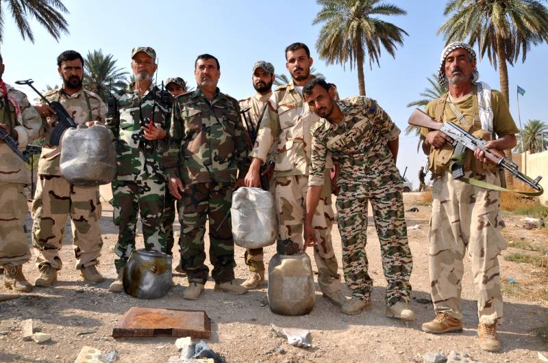 Volontari sciiti a Jurf al Shakar mostrano i bidoni usati dai miliziani jihaidsti per le trappole esplosive