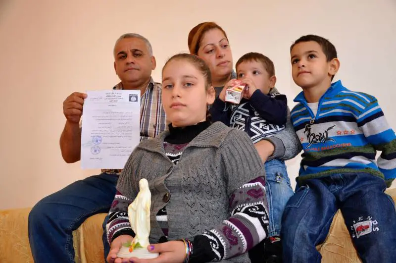 La famiglia al completo con il documento del Califfato sula conversione (forzata) dei cristiani con i nuovi nomi musulmani dei tre figli della coppia cristiana
