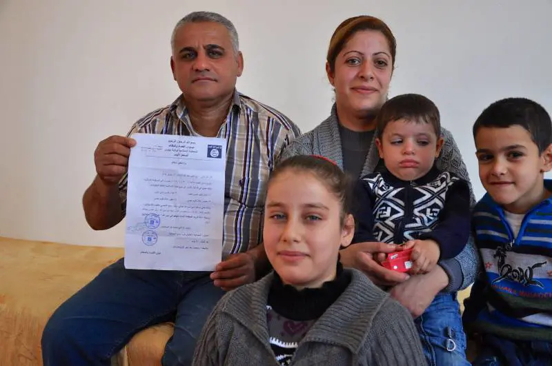 La famiglia al completo con il documento del Califfato sula conversione (forzata) dei cristiani con i nuovi nomi musulmani dei tre figli della coppia cristiana