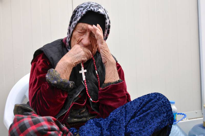 Un'anziana rifugiata cristiana cieca ad Erbil in Kurdistan prega il rosario