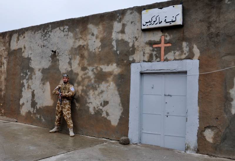 Volontario cirstiano a Bakufa sul fronte nord di Mosul presidia l'ingresso della chiesa di San Giorgio