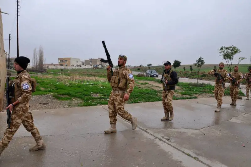 Volontari cristiani in pattuglia nel villaggio abbandonato di Bakufa sul fronte a nord di Mosul