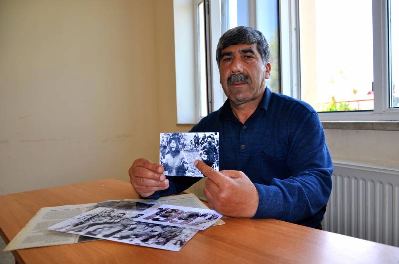 L'ex combattente Oruj Jabbarov con al foto del massacro di Kojali del 1992 quando portò in slavo una bambina 