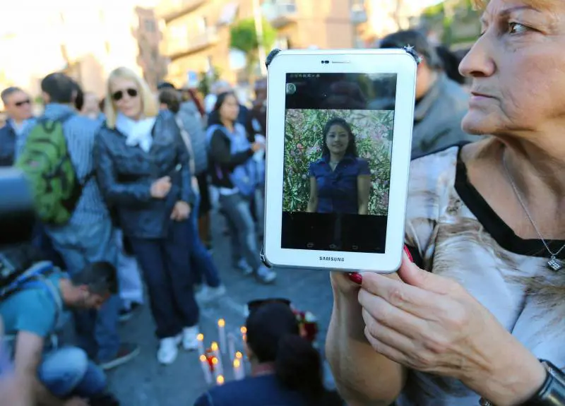 Una donna mostra un'immagine di Corazon Perez Abordo