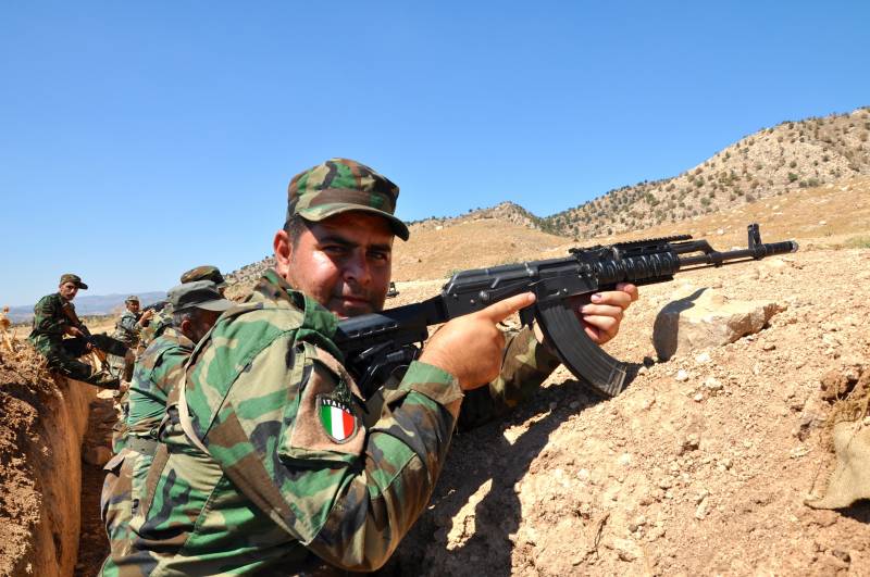 Una recluta curda in trincea con lo scudetto italiano