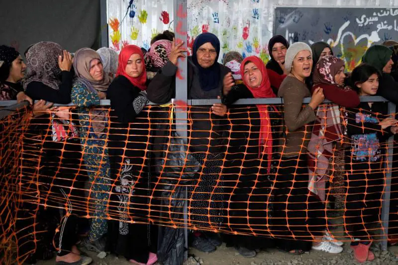 Donne in coda per i vestiti al campo tra Grecia e Macedonia