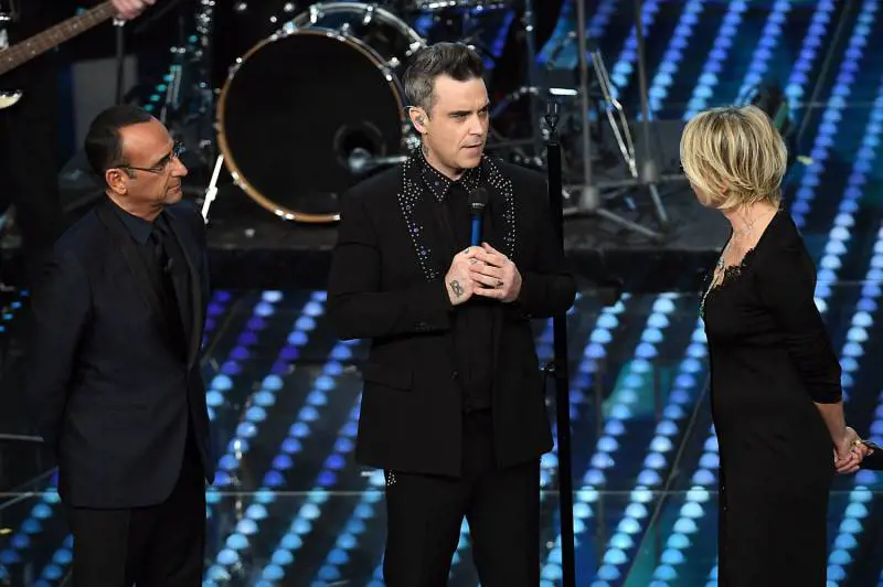 Sanremo, Robbie Williams incanta il teatro Ariston e bacia in bocca la De Filippi
