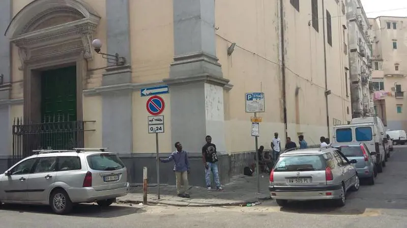 Un gruppo di immigrati che bivacca in via Milano