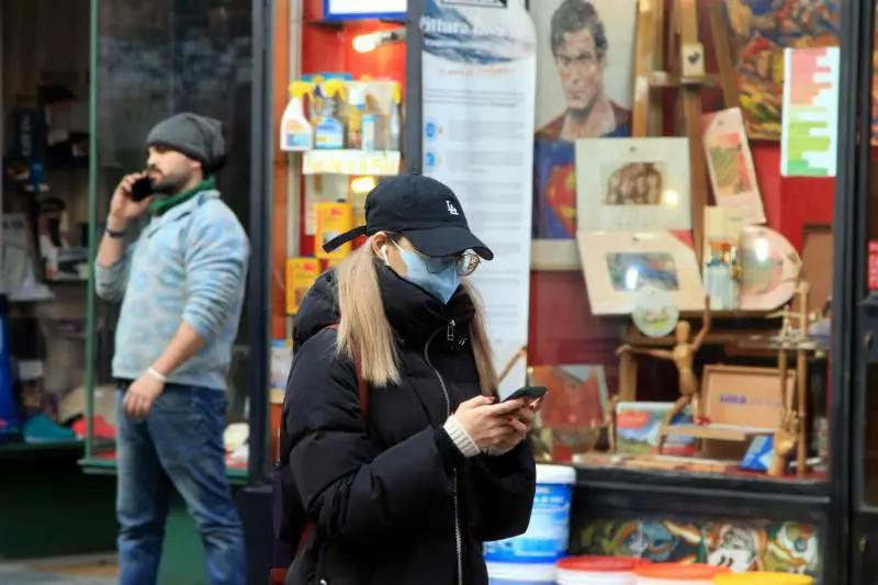 Una donna indossa una mascherina contro il Coronavirus in via Paolo Sarpi a Milano