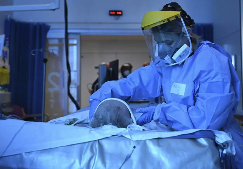 Un medico indossa i dispositivi di sicurezza per trattare il paziente (LaPresse)