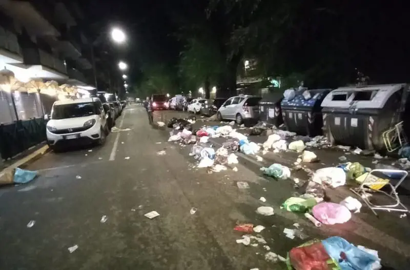Incappucciati gettano i sacchi dell'immondizia per strada