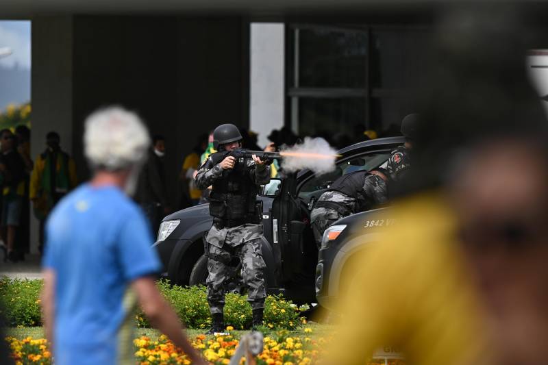 Un poliziotto spara dei lacrimogeni contro i protestanti al Planalto
