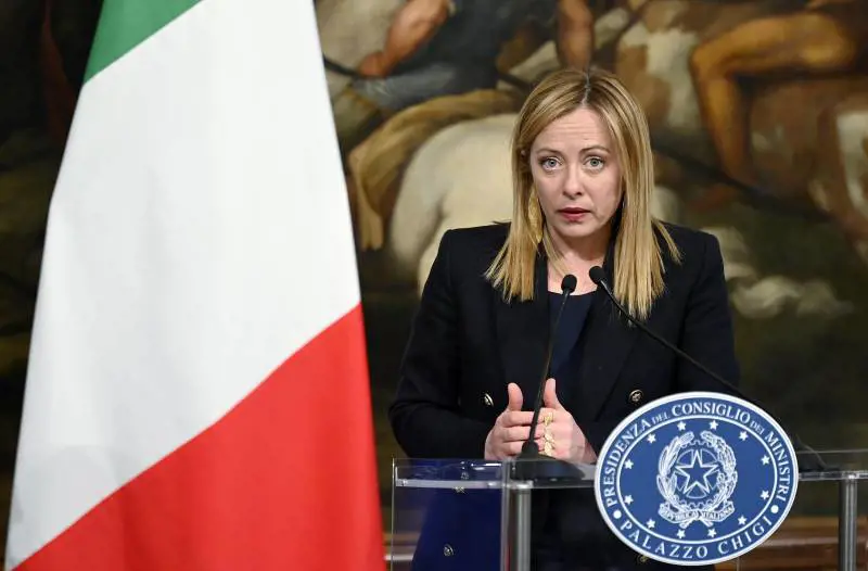 Meloni tace ancora sul caso Delmastro. E vola a Berlino seguita dall'ombra di dubbi e polemiche