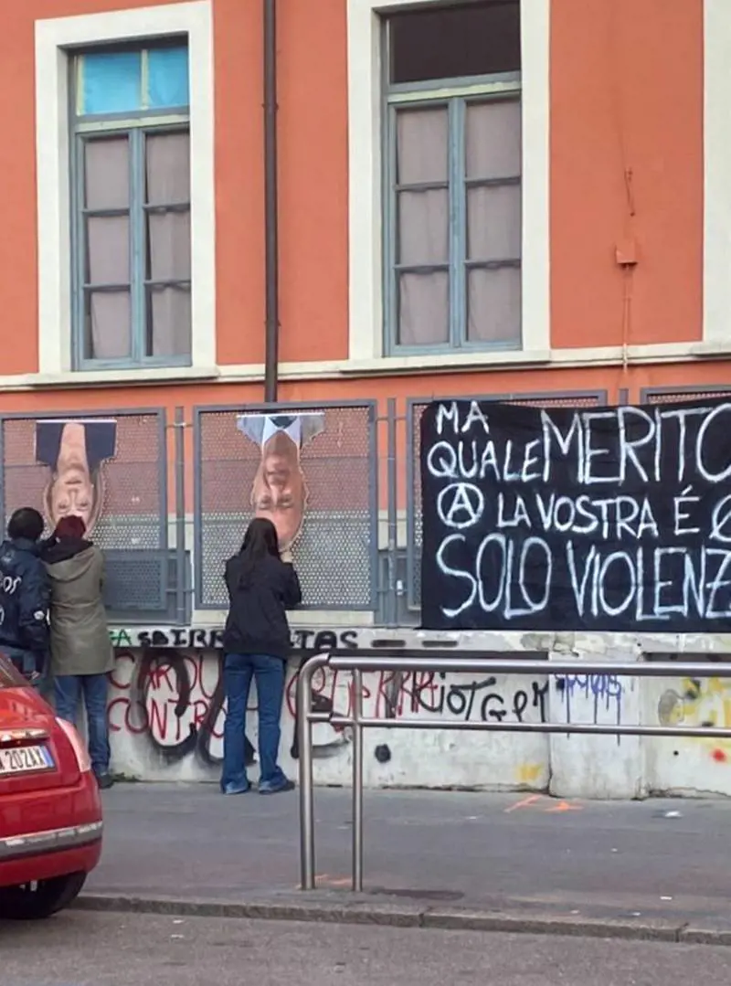 Meloni e Valditara a testa in giù: i media di sinistra insabbiano la violenza anarchica