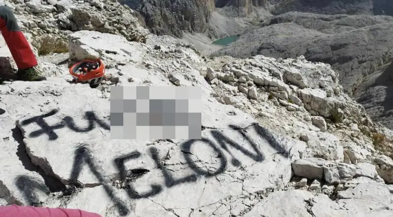 la frase offensiva composta sulla roccia con la bomboletta spray