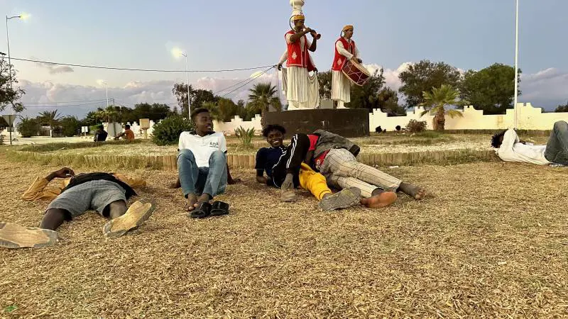 Migranti bivaccati in una piazzetta di Zarzis.
