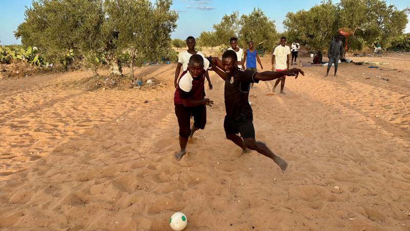I migranti giocano a calcio alla periferia di El Amra in attesa dell imbarco per Lampedusa.