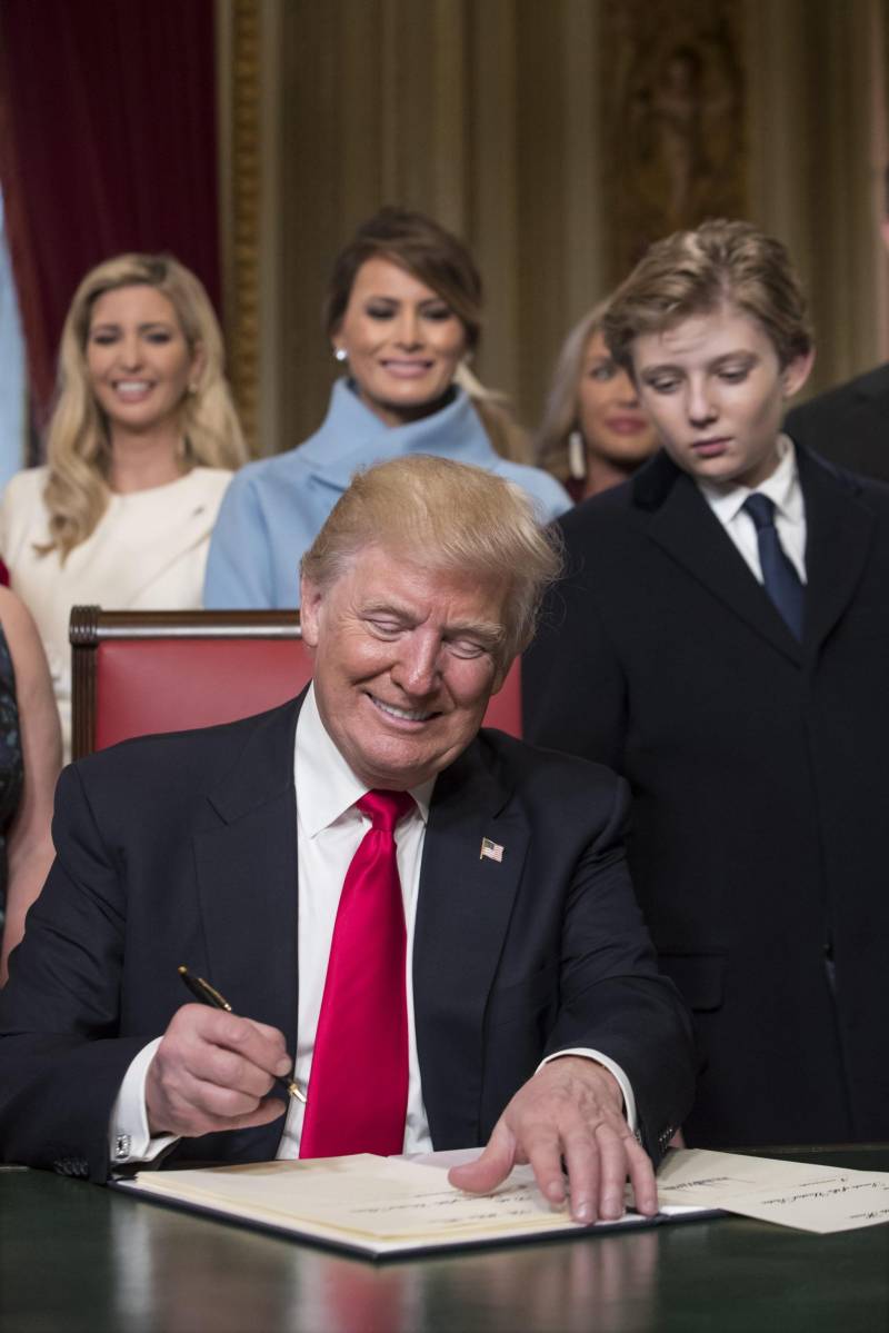 Il Presidente Donald Trump con la sua famiglia nella sala Presidenziale per le prime firme del suo mandato (gennaio 2017) 