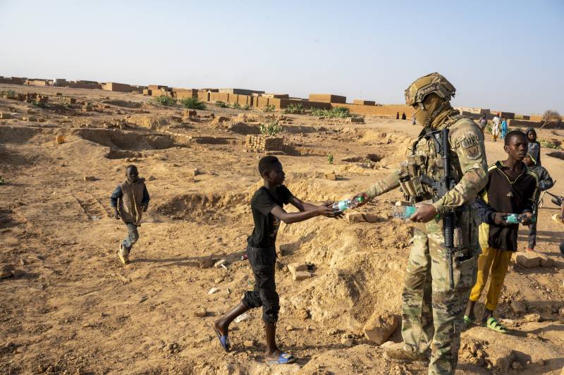 Un aviatore dell'aeronautica statunitense membro della Quick Reaction Force del 409th squadron, consegna una bottiglia d'acqua a un bambino vicino alla base aerea 201, Niger, 6 gennaio 2023.