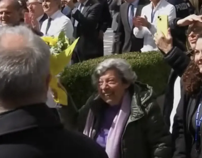 La signora Carmela con il mazzo di rose gialle mentre viene salutata da Papa Francesco