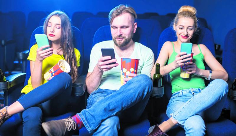 Davanti al grande schermo con un piccolo smartphone