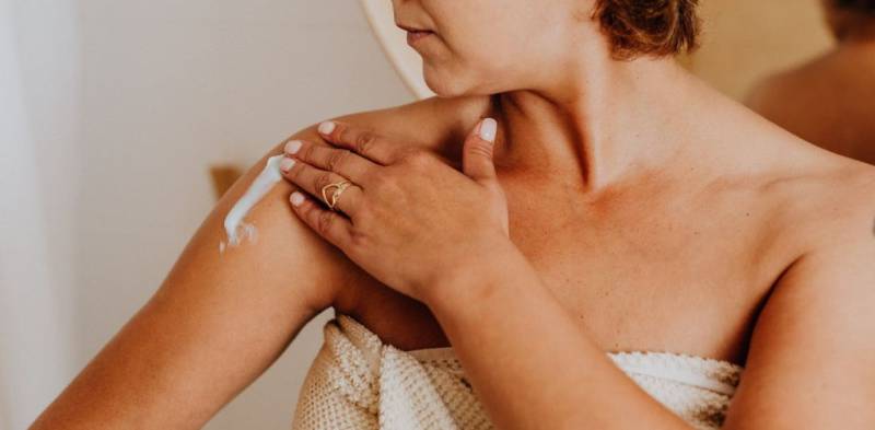 Donna che si spalma la crema