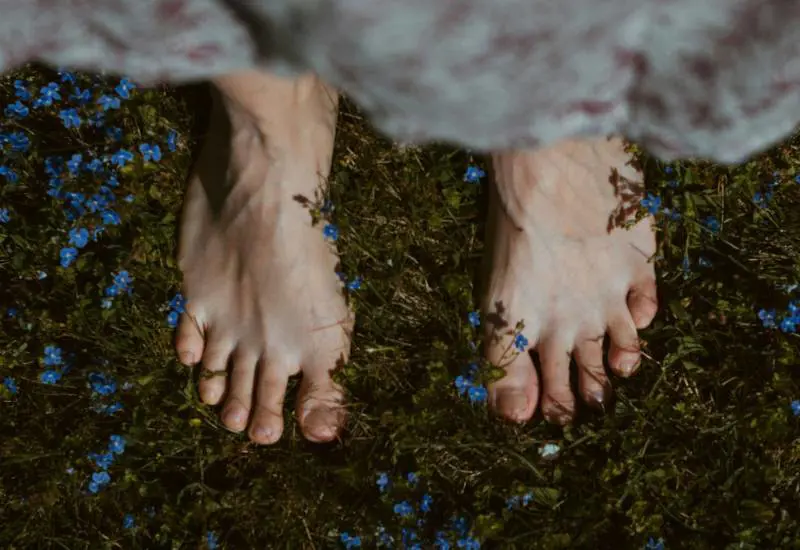 Grounding mania, camminare a piedi nudi nel verde: perché fa bene