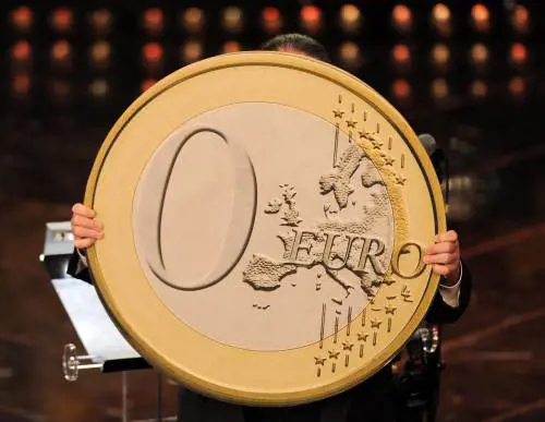 Massimo Morini, direttore d'orchestra,mostra una moneta da 0 euro