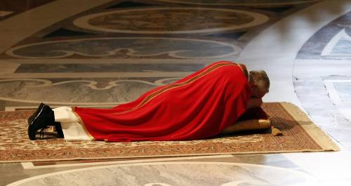 Papa Francesco sdraiato a terra per adorare la croce