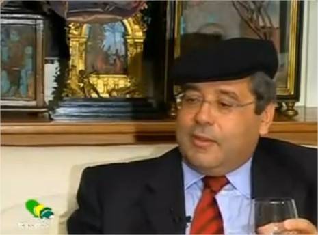 Totò Cuffaro con la coppola e un bicchiere di vino
