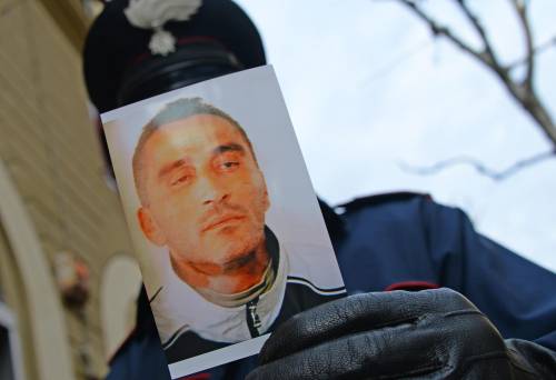 Un carabiniere con la foto segnaletica di Pietro Esposito