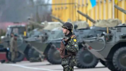 Un soldato ucraino di guardia a mezzi dell'esercito a Lviv, nell'Ucraina occidentale