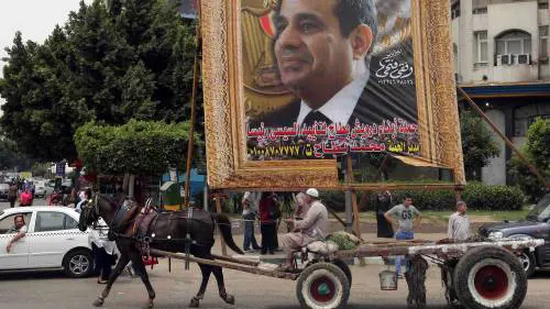 Un manifesto con il volto di Abdel Fath al-Sisi in una strada della periferia del Cairo