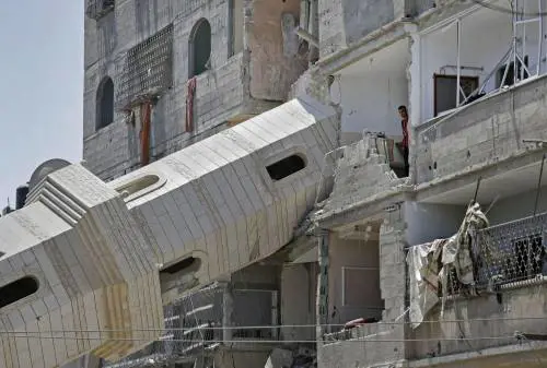 Il minareto della moschea al-Susi, distrutta da uno strike e le case vicine