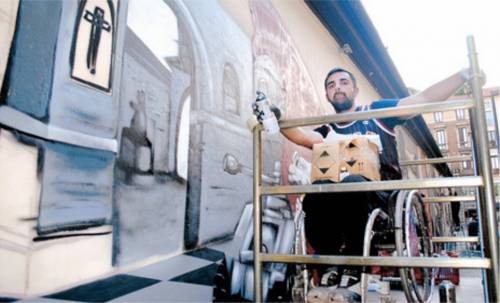 Il Michelangelo dello spray dipinge sulla sedia a rotelle