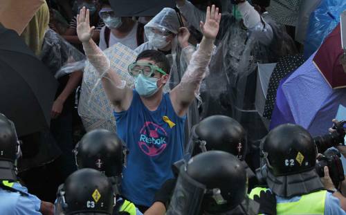 Poliziotti spruzzano spray irritante al peperoncino contro i dimostranti nel centro di Hong Kong 
