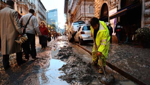 Un volontario alle prese col fango a Genova. Ma il maltempo ha messo in ginocchio il Nord Italia, compresa la Toscana. Le regioni chiedono ora lo stato di calamità